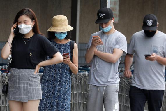 People wear protective face masks outside at a shopping plaza in Edgewater New Jersey, on July 8, 2020.
Reuters
